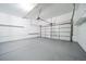Garage with a gray painted floor and white shelving and a garage door at 1673 S Fulton St, Aurora, CO 80247