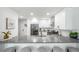 Modern kitchen featuring white cabinets, stainless steel appliances, and a large gray countertop with seating at 1673 S Fulton St, Aurora, CO 80247