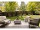 Backyard patio with outdoor seating and a modern fire pit feature surrounded by green trees at 4121 S Cherry St, Cherry Hills Village, CO 80113