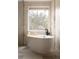 Bright bathroom featuring a freestanding tub with a stone accent wall and large window at 4121 S Cherry St, Cherry Hills Village, CO 80113