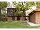Exterior elevation of a brick home with copper roof and mature trees at 4121 S Cherry St, Cherry Hills Village, CO 80113