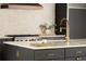 Modern kitchen featuring dark cabinetry, stainless steel appliances, marble countertops and gold fixtures at 4121 S Cherry St, Cherry Hills Village, CO 80113