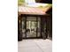 An outdoor patio featuring spiral topiary plants, leading to open sliding doors and a glimpse of the stylish living room at 4121 S Cherry St, Cherry Hills Village, CO 80113