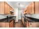 Kitchen with wood cabinets, dark counters, and stainless steel appliances at 16359 W 10Th Ave # Yy3, Golden, CO 80401