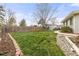 Lush backyard featuring a well-maintained lawn, garden beds, and a wooden fence, perfect for outdoor enjoyment at 5440 W Hinsdale Ave, Littleton, CO 80128