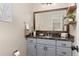 Powder room featuring a stylish vanity with granite countertop, framed mirror, and open shelving at 5440 W Hinsdale Ave, Littleton, CO 80128
