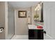 Bathroom featuring a black vanity with white sink, frameless shower, and modern lighting at 5440 W Hinsdale Ave, Littleton, CO 80128