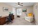 Cozy bedroom area featuring a ceiling fan, neutral walls, carpet floors, and a comfortable chair with a throw blanket at 5440 W Hinsdale Ave, Littleton, CO 80128