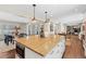 View of the kitchen island with a butcher block top and seating in an open-concept layout at 5440 W Hinsdale Ave, Littleton, CO 80128
