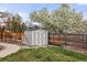 Backyard shed surrounded by lush greenery and a privacy fence, offering practical storage space at 5440 W Hinsdale Ave, Littleton, CO 80128
