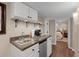 Basement wet bar featuring white cabinetry, granite countertops, a sink, and a small refrigerator at 5440 W Hinsdale Ave, Littleton, CO 80128