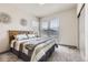 Comfortable bedroom with large window, striped bedding, and neutral decor at 6863 E 132Nd Pl, Thornton, CO 80602
