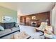 Spacious living room featuring wood paneling, a brick fireplace, comfortable seating, and neutral carpet at 4257 Graham Ct, Boulder, CO 80305