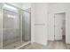 Modern bathroom featuring a glass-enclosed shower with tile surround, and vinyl flooring at 8229 Butte Creek St, Littleton, CO 80125