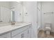 Bathroom featuring a large mirror, quartz countertops, and a pristine white vanity at 8229 Butte Creek St, Littleton, CO 80125