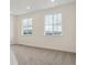Bright bedroom featuring two windows offering expansive exterior views and plush gray carpeting at 8229 Butte Creek St, Littleton, CO 80125
