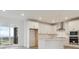 Bright kitchen has white cabinets and stainless appliances at 8229 Butte Creek St, Littleton, CO 80125