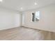 Bright, white-walled living room with light wood floors and a door to the outside at 8229 Butte Creek St, Littleton, CO 80125