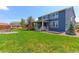 Spacious backyard with a well-kept lawn, patio, and fire pit at 2474 Ravenswood Ct, Longmont, CO 80504
