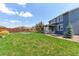 Spacious backyard featuring a manicured lawn, patio, and mature landscaping at 2474 Ravenswood Ct, Longmont, CO 80504