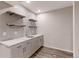 A modern bar area featuring gray cabinets, quartz countertops, backsplash tile, open shelving, and stylish faucet at 2474 Ravenswood Ct, Longmont, CO 80504