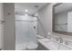 Bathroom featuring a glass shower with white subway tile, gray walls, and a light countertop at 2474 Ravenswood Ct, Longmont, CO 80504