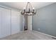 This bedroom features a modern chandelier, plush carpet, and access to an adjacent room at 2474 Ravenswood Ct, Longmont, CO 80504