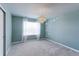 Bright bedroom features neutral walls, plush carpet, large window and modern chandelier at 2474 Ravenswood Ct, Longmont, CO 80504