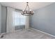 Bright bedroom features neutral walls, plush carpet, large window and modern chandelier at 2474 Ravenswood Ct, Longmont, CO 80504