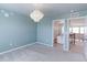 Bright bedroom featuring a modern chandelier, plush carpet, and access to an adjacent room at 2474 Ravenswood Ct, Longmont, CO 80504