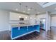 Open kitchen with white cabinets, a blue island, granite countertops and stainless steel appliances at 2474 Ravenswood Ct, Longmont, CO 80504