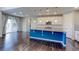 Bright kitchen with white cabinetry, a blue island with granite countertops, and a patio door at 2474 Ravenswood Ct, Longmont, CO 80504