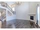 Bright, open-plan living room with a fireplace, wooden floors, and a staircase to the upper level at 2474 Ravenswood Ct, Longmont, CO 80504