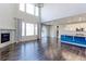 Bright open-plan living room with a kitchen, a fireplace, a patio door, and large windows at 2474 Ravenswood Ct, Longmont, CO 80504