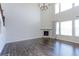 Open-plan living room featuring wooden floors, a fireplace, large windows, and a vaulted ceiling at 2474 Ravenswood Ct, Longmont, CO 80504