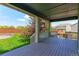 Covered patio featuring wood flooring and railings, providing a relaxing outdoor space with a view of the yard at 2474 Ravenswood Ct, Longmont, CO 80504