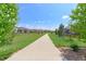 A concrete walking path meanders through a green space in a residential community at 2474 Ravenswood Ct, Longmont, CO 80504