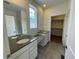 Spacious bathroom featuring double sinks, tile flooring, and a walk-in closet at 5025 N Quemoy St, Aurora, CO 80019