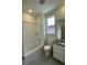 Bright bathroom features a shower over tub, a toilet, and a vanity with modern finishes at 5025 N Quemoy St, Aurora, CO 80019