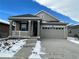 Charming single-Gathering home featuring a covered porch, gray siding, and a two-car garage at 5025 N Quemoy St, Aurora, CO 80019