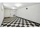Unfinished basement with checkerboard tile, white walls, and access to other rooms at 618 S Franklin St, Denver, CO 80209