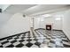 Open basement with black and white tile floor, white walls and view of the fireplace at 618 S Franklin St, Denver, CO 80209