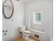 Classic bathroom featuring a decorative mirror, white fixtures, and a window that provides soft natural light at 618 S Franklin St, Denver, CO 80209