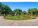 Playground with modern swings and climbing structure surrounded by trees at 618 S Franklin St, Denver, CO 80209