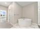 Bright bathroom featuring a luxurious soaking tub, stand-alone shower, and stylish marble floors at 2323 Lakeshore Ln # 11, Superior, CO 80027