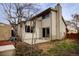 Backyard view shows the home's exterior, small concrete patio, sliding glass door, and trees at 11771 Pennsylvania St, Northglenn, CO 80233