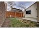 View of backyard featuring a wood fence, sparse trees, and a small concrete patio with a grass yard at 11771 Pennsylvania St, Northglenn, CO 80233