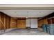 Spacious garage with open door, work bench, storage shelving, and concrete flooring at 11771 Pennsylvania St, Northglenn, CO 80233