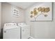 Bright laundry room features a washer and dryer, and stylish wall art at 4410 Cattle Cross Rd, Castle Rock, CO 80104