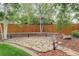 A backyard patio area with a stone paver patio and terraced seating area with a wood fence at 14910 Williams St, Thornton, CO 80602